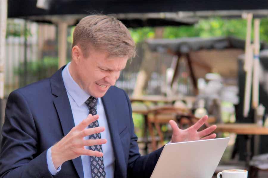 Empresário irritado com a internet lenta no notebook durante o trabalho